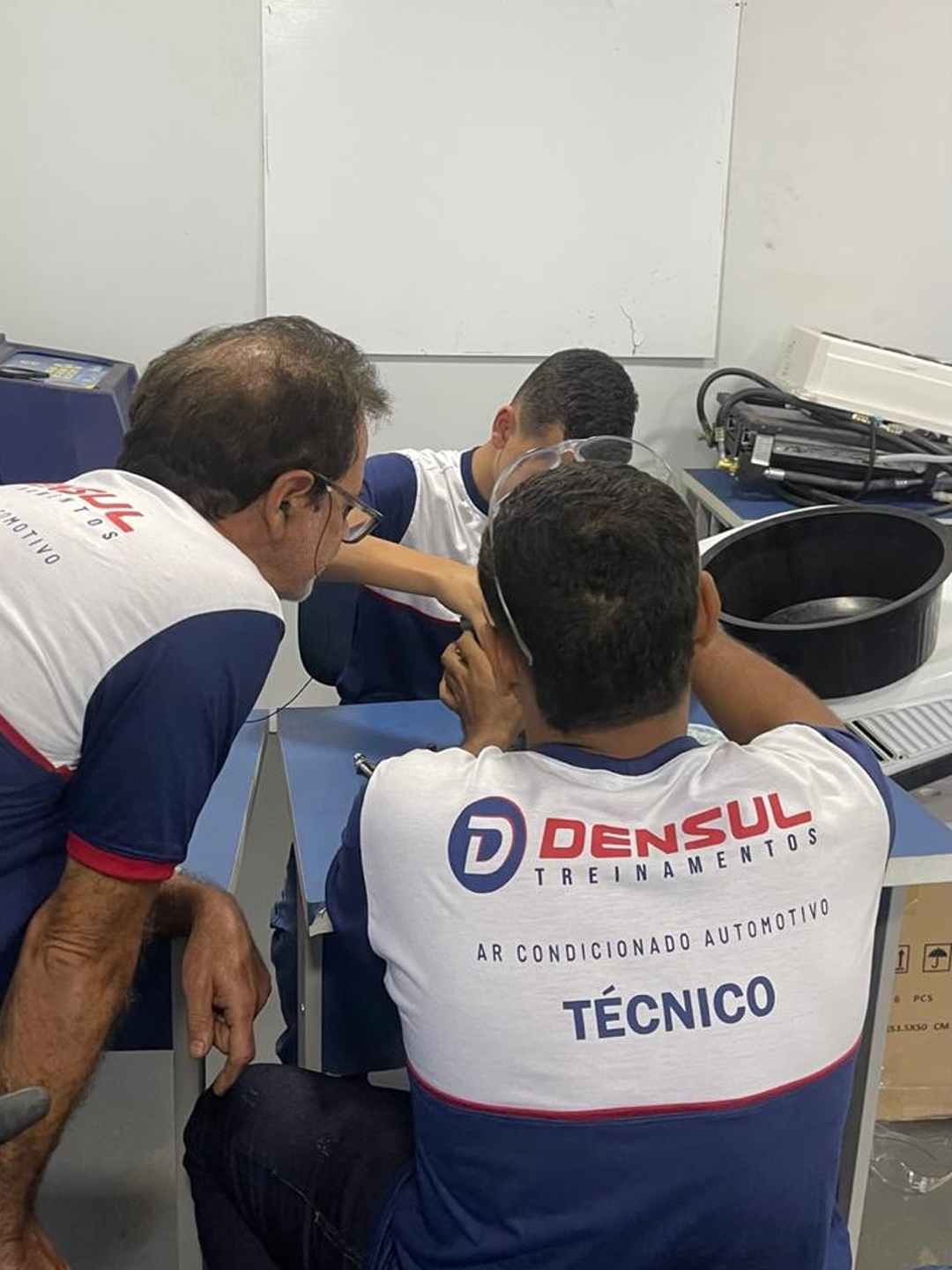 Instrutor acompanhando alunos no treinamento técnico
